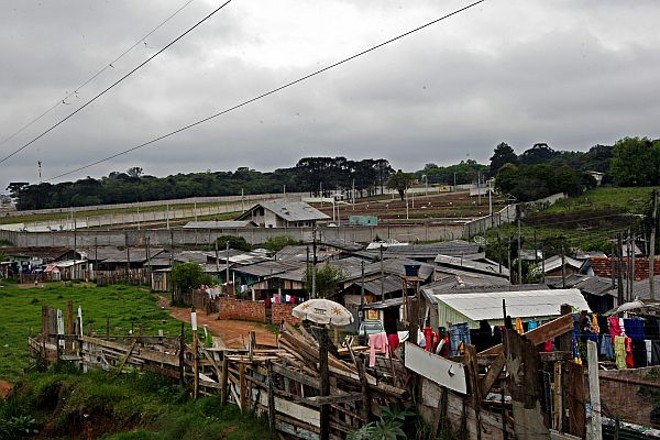 A ocupação: Cerca de 12 mil moradores do Umbará vivem em favelas e loteamentos clandestinos. A soma corresponde a quase 70% do bairro, o que derruba seu mito de prosperidade. Na foto, muro de futuro condomínio faz divisa com a ocupação Unidos Umbará |
