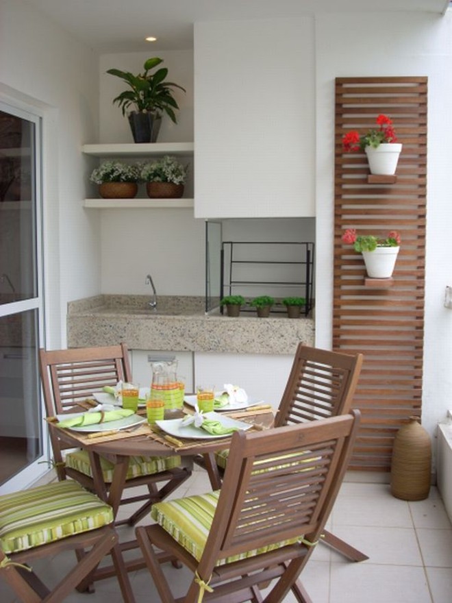 Elegância discreta: as arquitetas Estér Kloss e Helaine Góes optaram por transformar a churrasqueira deste apartamento em um pequeno espaço gourmet. Uma mesa de refeições no centro e um banco no canto oposto à churrasqueira foram os mobiliários escolhidos para compor o ambiente. Tudo em um conceito bem limpo, sem sobrecarregar a fachada do prédio. Vasos pendurados em um quadro de madeira dão um charme especial ao local |