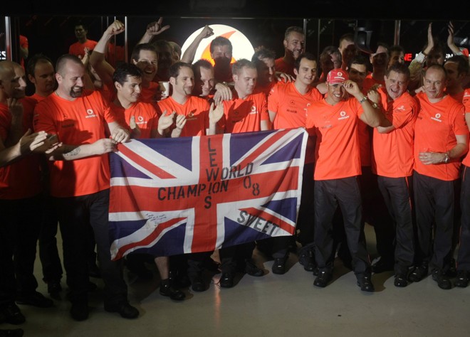 Mecânicos da McLaren posam com o campeão Lewis Hamilton |
