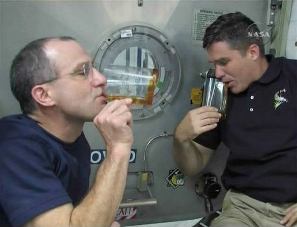 Pettit (esq.) inventou uma xícara para gravidade zero, que retém o líquido junto a paredes feitas de plástico dobrado | NASA TV / Reuters
