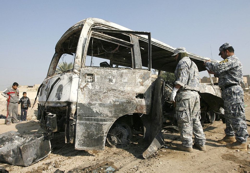 Policiais inspecionam destroços do ônibus em Bagdá. Ataque se soma as várias séries de explosões na capital iraquiana | Thaier al-Sudani / Reuters