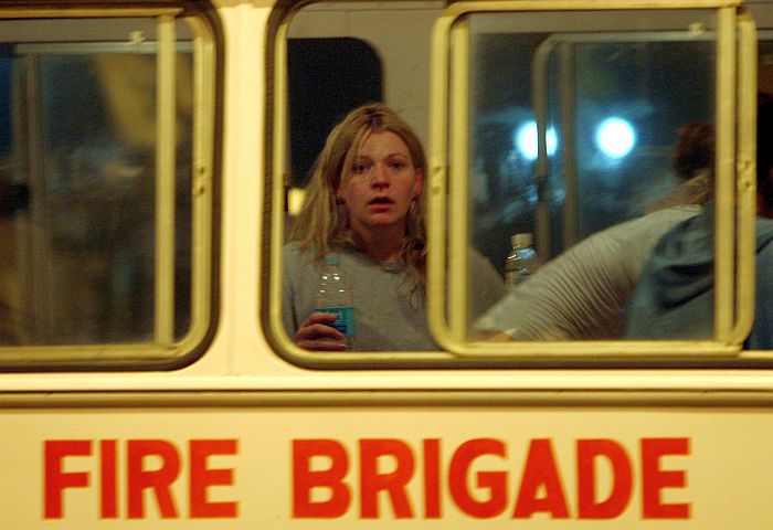 Ex-refém estrangeira bebe água em ônibus do Corpo de Bombeiros após ser liberada pelas forças armadas da Índia. Ela estava no Hotel Taj Mahal, em Mumbai | Punit Paranjpe/Reuters