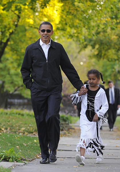 Obama leva a filha, Sasha, 7 anos, para a festa de Halloween, em Chicago: imagem familiar reforça popularidade do democrata. | Emmanuel Dunand/AFP
