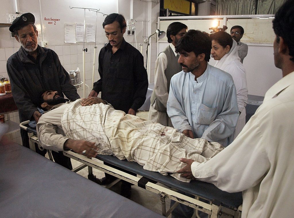 Afegãos carregam uma vítima de um dos atentados suícida próximo a um hospital em Peshawar | Ali Imam / Reuters