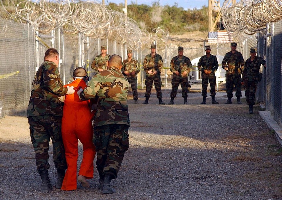 Imagem mostra policiais escoltando detento até sua cela, em 2005. Desde 2002, mais de 750 prisioneiros foram recebidos; 255 homens continuam presos em Guantánamo | Shane T. McCoy / Reuters