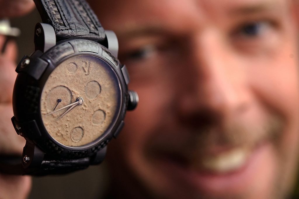 Chefe-executivo da Romain Jerome, Yvan Arpa, segura um prototipo de relógio feito com poeira lunar. Em 2007, a empresa gerou polêmica com seus relógios "DNA Titanic", feitos de aço e carvão retirados do navio que naufragou em 1912 | Fabrice Coffrini / AFP Photo
