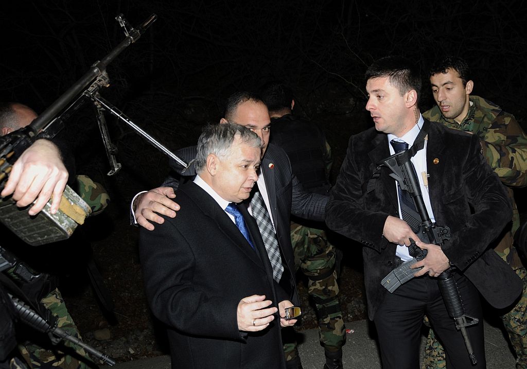 Seguranças protegem o presidente polonês Lech Kaczyinski, após tiroteio que ocorreu perto da carreata que transportava o presidente georgiano e ele | Irakli Gedenidze/Reuters