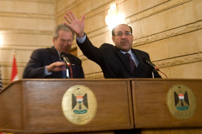 O primeiro-ministro iraquiano, Nuri al-Maliki, tenta proteger Bush dos sapatos | Saul Loeb/AFP