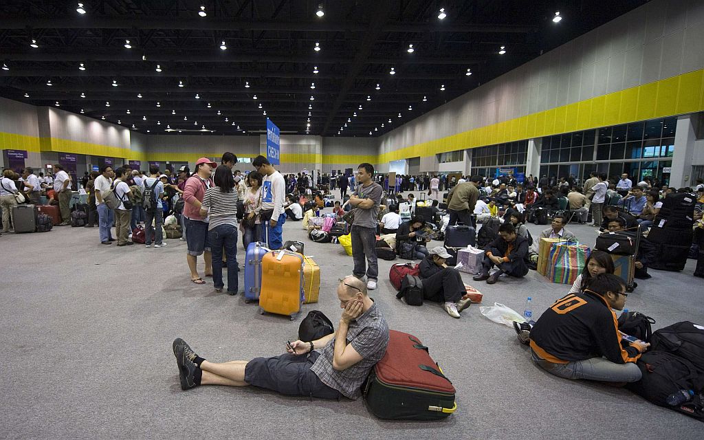 Turistas que estão presos no terminal de aeroporto de Bagcoc aguardam para fazer o check-in | Adrees Latif / Reuters