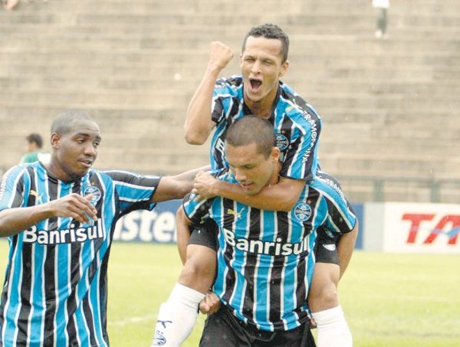 Perea e Souza (alto) comemoram com Marcel, autor de dois gols na vitória do Grêmio por 4 a 1 sobre o Ipatinga, no Ipatingão | 