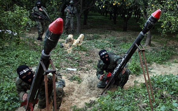 Mascarados e na Faixa de Gaza, militantes palestinos preparam foguetes a serem lançados contra Israel, nesta quarta-feira (24) | Reprodução/G1/Ashraf Amra