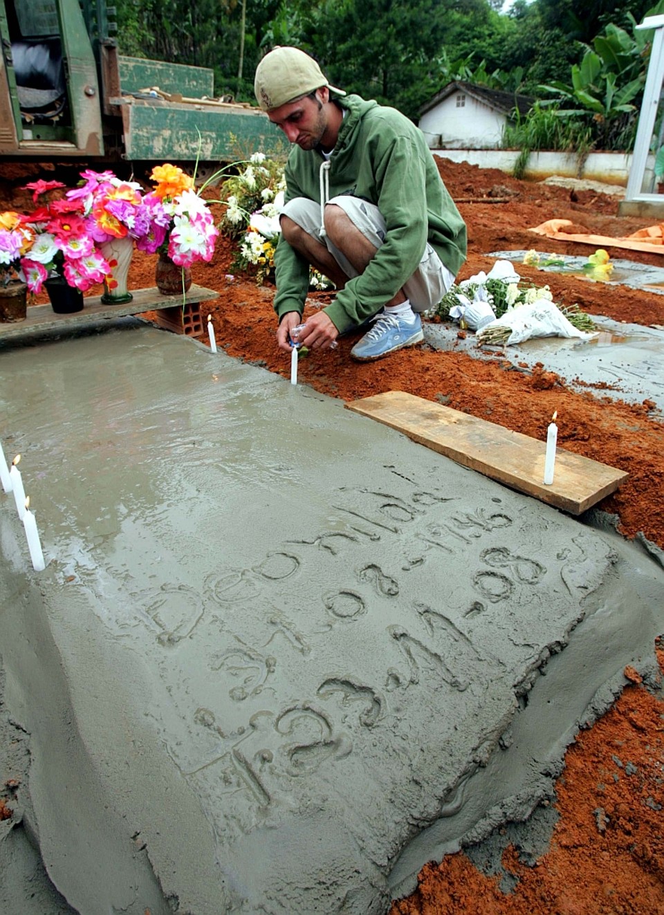 Matias acende uma vela para a mãe: no cimento fresco, a última homenagem | Daniel Castelano/Gazeta do Povo