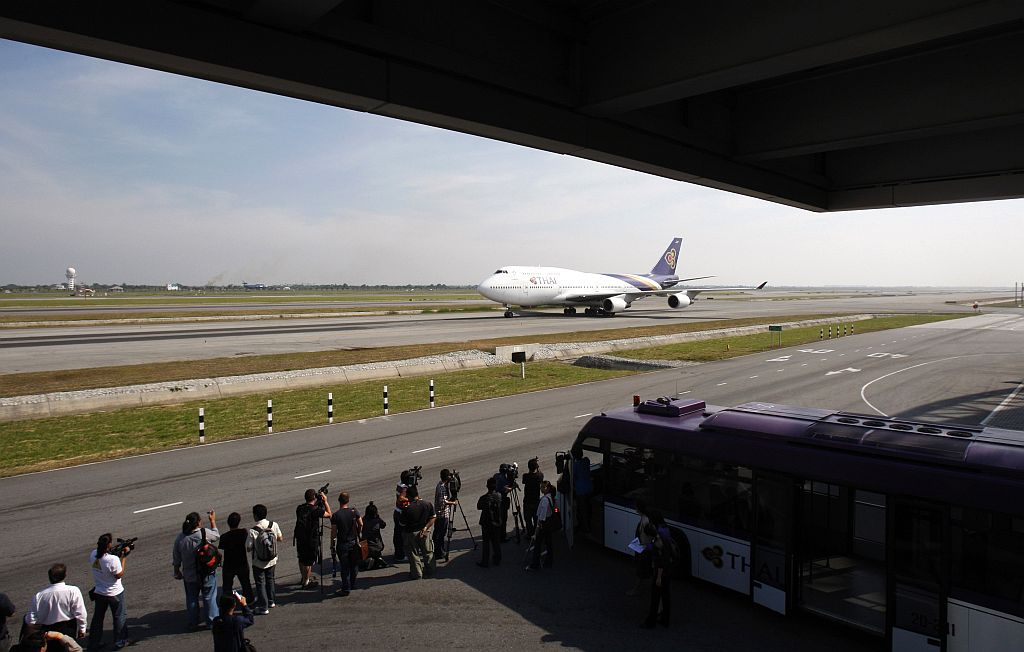 Jornalistas filmam um vôo da Thai Airways, o primeiro a aterrisar do aeroporto de Suvarnabhumi, em Bangcoc | Chaiwat Subprasom / Reuters
