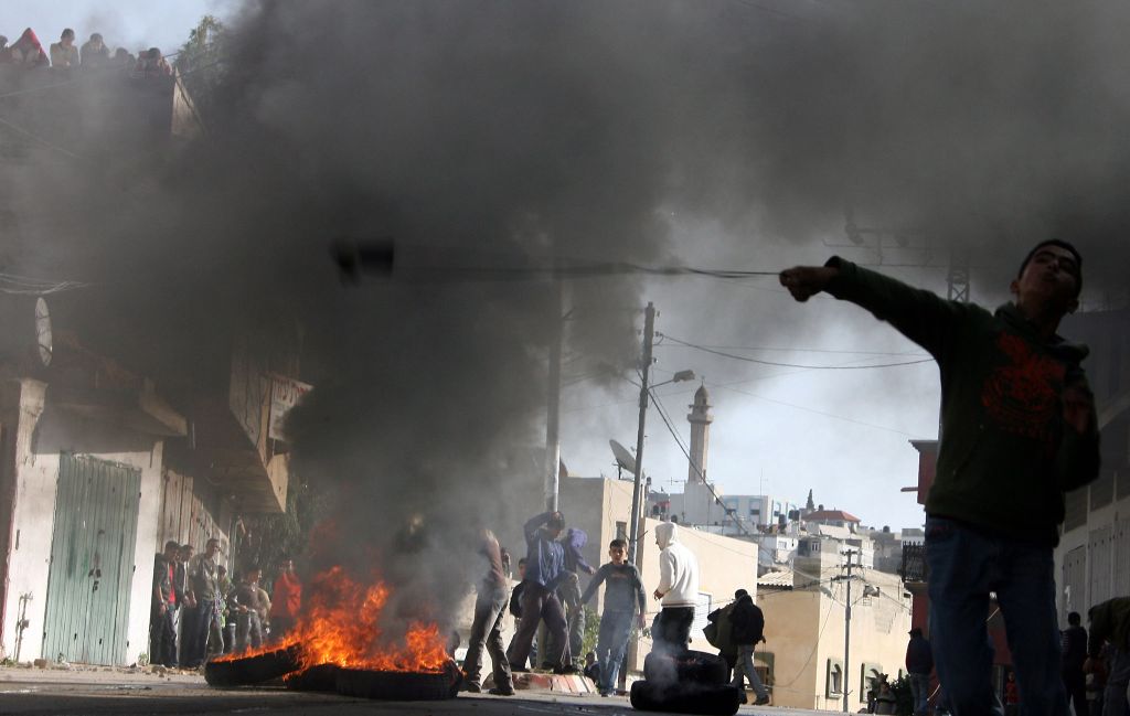 Palestino da Cisjordânia atira pedra contra soldados israelenses: árabes de toda a região se manifestaram contra Israel | Jaafar Ashtiyeh/AFP