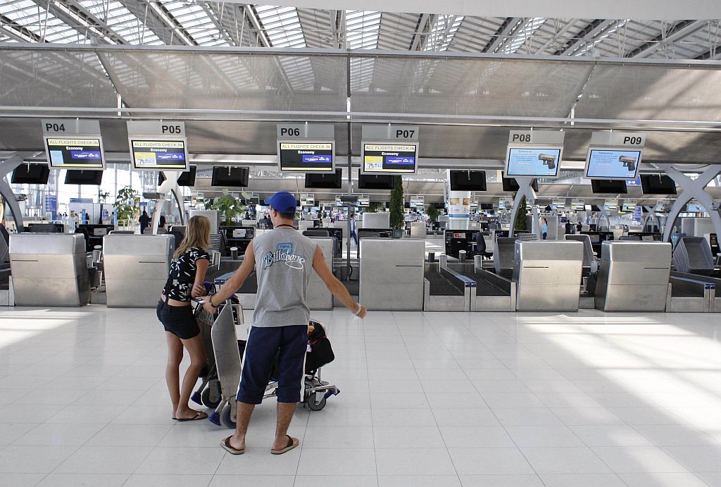 Passageiros observam terminal e guichê do check-in vazios no aeroporto de Suvarnabhumi, na Tailândia | Darren Whiteside / Reuters