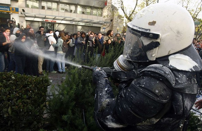 Policial atira spray de gás em manifestantes no centro de Atenas, em mais um conflito na capital grega | Yiorgos Karahalis / Reuters