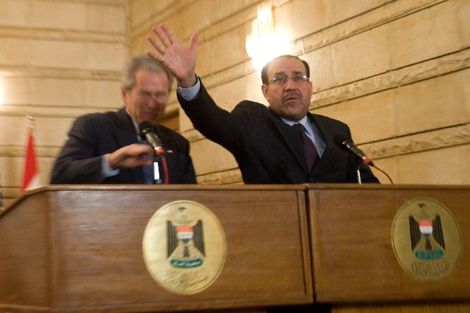 O premiê do Iraque, Nuri al-Maliki, protege Bush de sapato lançado por repórter iraquiano durante coletiva em Bagdá | Saul Loeb/AFP