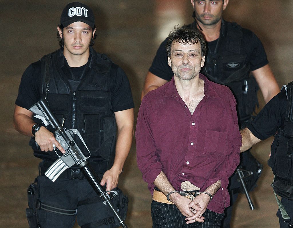 Ativista político Cesare Battisti (centro) foi fotografado, em 19 de março de 2007, no aeroporto de Brasília | Evaristo SA / AFP Photo