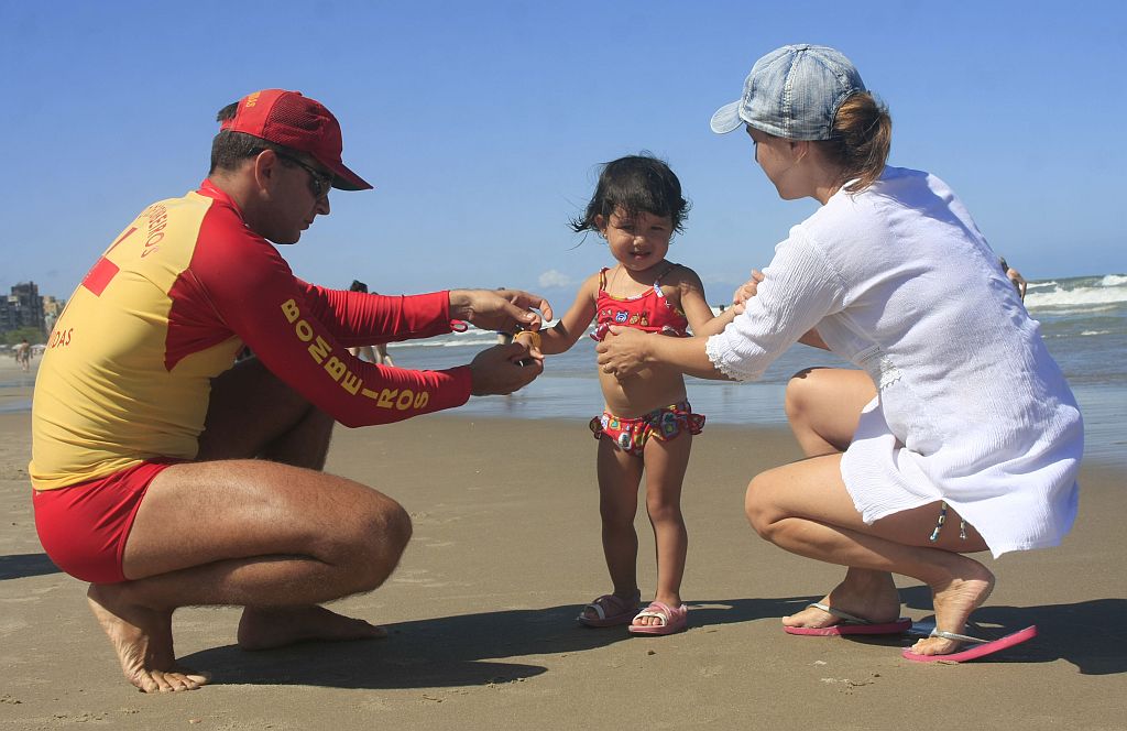 Mesmo com a filha Anna identificada com a pulseira, a dentista Cláudia Arima não perde a menina de vista um minuto | Giuliano Gomes/Gazeta do Povo