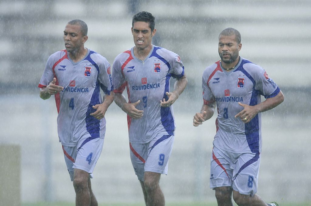 Wellington Silva, Hernani e Lenilson correm no gramado da Vila Capanema no primeiro dia de treino paranista: a chuva forte atrapalhou a reapresentação | Giuliano Gomes/Gazeta do Povo