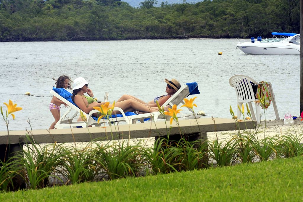 Veranistas tomam banho de sol na praia particular em frente ao Iate Clube de Caiobá | Giuliano Gomes/Gazeta do Povo