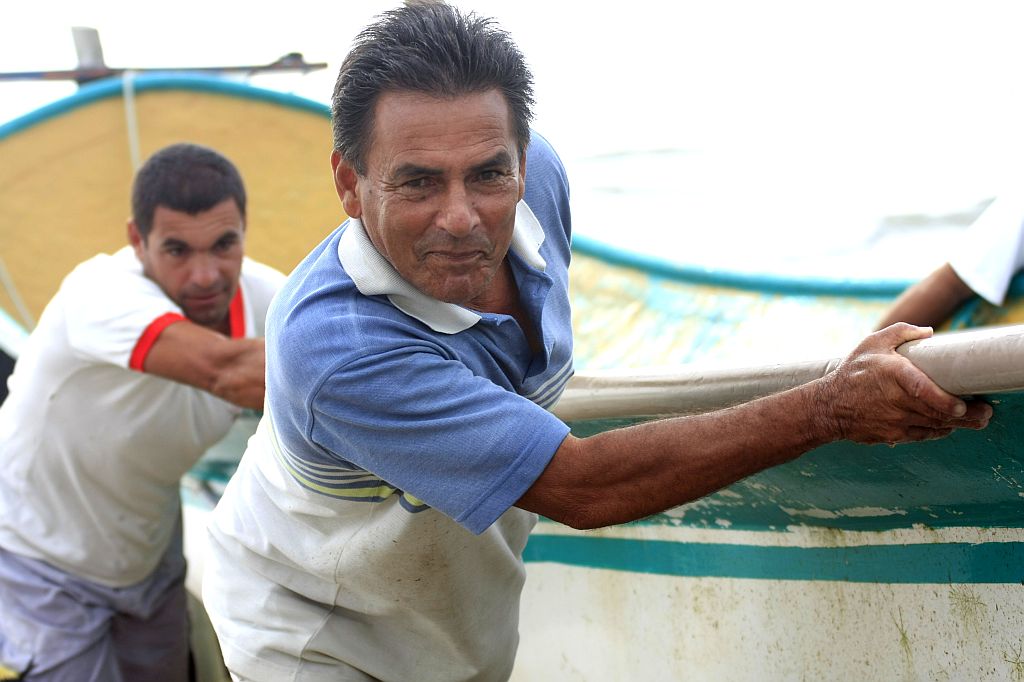 João Joaquim da Silva, o Jango: 45 anos vivendo da pesca, profissão que herdou do pai quando tinha apenas 15 anos de idade. Logo atrás, seu cunhado, Joel Maguila | Giuliano Gomes/Gazeta do Povo