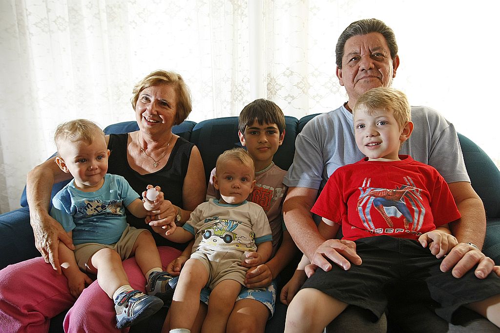 Dirce e o marido, Nereu, com os netos Luan (centro), os gêmeos Caio e Vítor, e Rafael, no colo do avô: casa cheia. | Antonio Costa/Gazeta do Povo