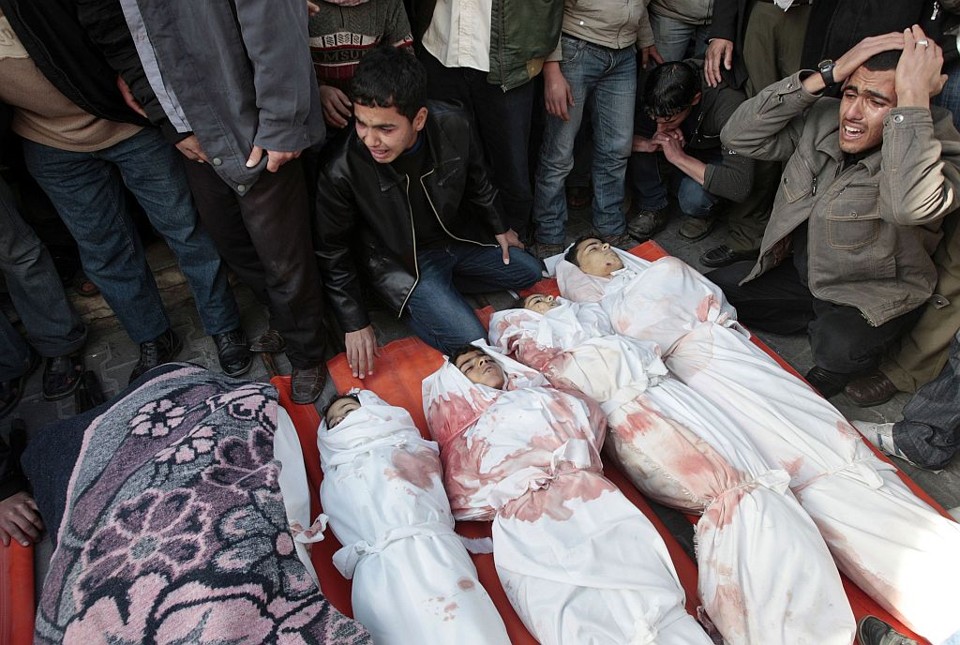 Palestinos choram sobre os corpos de crianças no funeral realizado na Faixa de Gaza | Mohammed Salem / Reuters