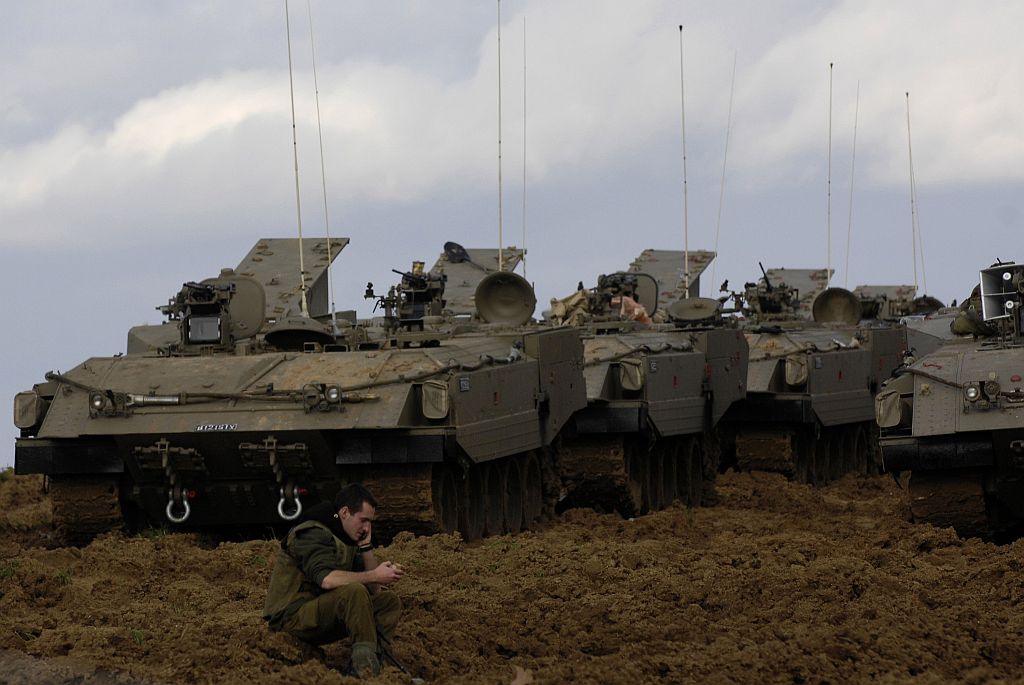 Soldado israelense sentado em frente aos tanques no centro da Faixa de Gaza: 420 mortos e mais 2.000 feridos desde sábado passado | Amir Cohen / Reuters