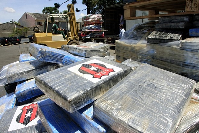 Símbolo de time da Costa Rica- A Colômbia é, até o momento, a origem mais provável da cocaína apreendida em Paranaguá pela Polícia Federal. A embalagem da droga, porém, tem um toque costa-riquenho. As fotografias tiradas durante a apreensão e durante a apresentaçção da droga em Curitiba mostram que as embalagens de vários dos tabletes de um quilo de cocaína têm imagens do Liga Deportiva Alajuelense, time de futebol da cidade de Alajuela, na Costa Rica. |