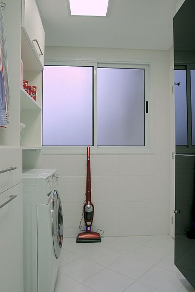 O projeto de Alessandra Gonçalves segue o estilo clean para a área de serviço, com piso e revestimentos brancos. | 