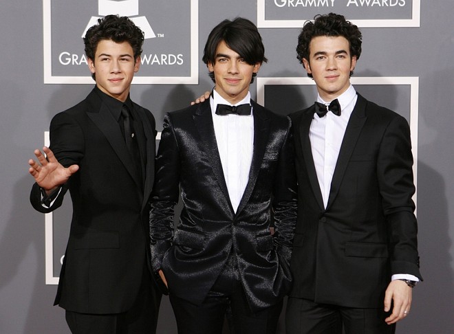 Não foram só as mulheres que brilharam no tapete vermelho: os irmãos Nick, Joe e Kevin dos Jonas Brothers foram destaque na premiação. Nick usou um terno Burberry com acessórios Neil Lane; Joe e Kevin usaram Versace, sendo que Joe optou por um modelo brilhante | 