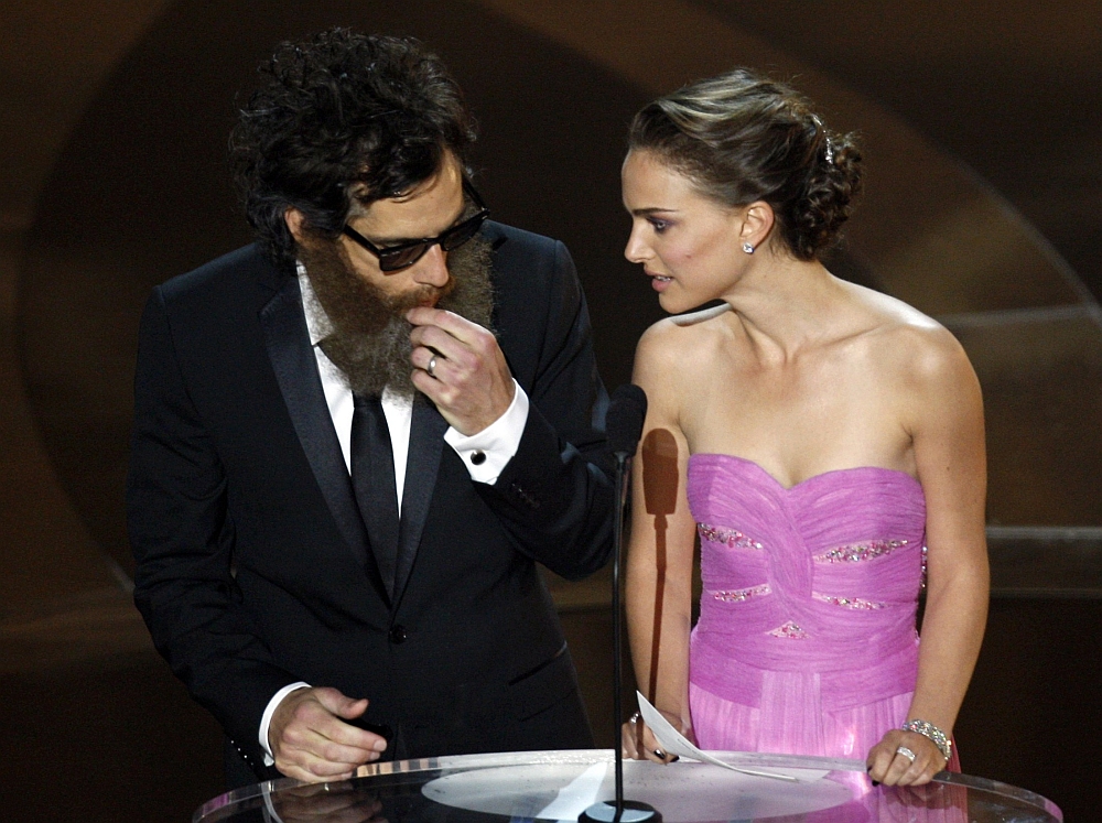 Ben Stiller, vestido como o ator Joaquin Phoenix, retira da boca um chiclete durante a premiação do Oscar | Reuters/Gary Hershorn