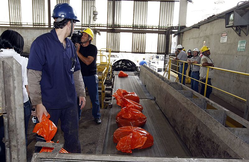 Operários a serviço da Polícia Federal colocam pacotes de cocaína em esteira que leva o material ao forno da indústria de cimento | Hedeson Alves/Gazeta do Povo