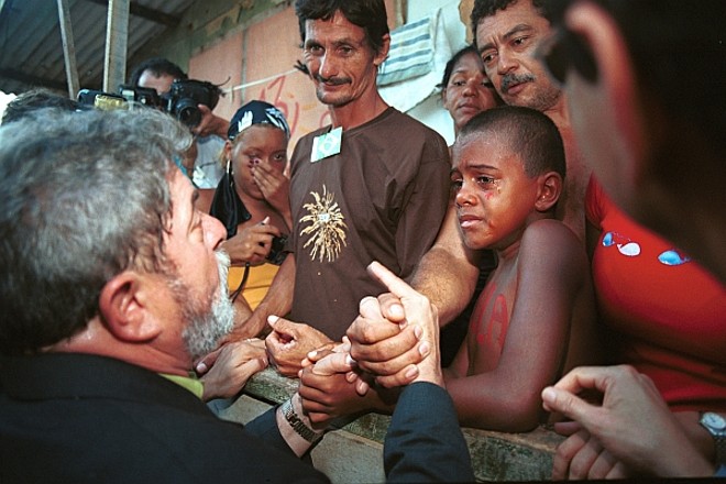 Criança da cidade de Lauro de Freitas, na Bahia, se emociona ao encontrar Lula, em janeiro de 2003. | 