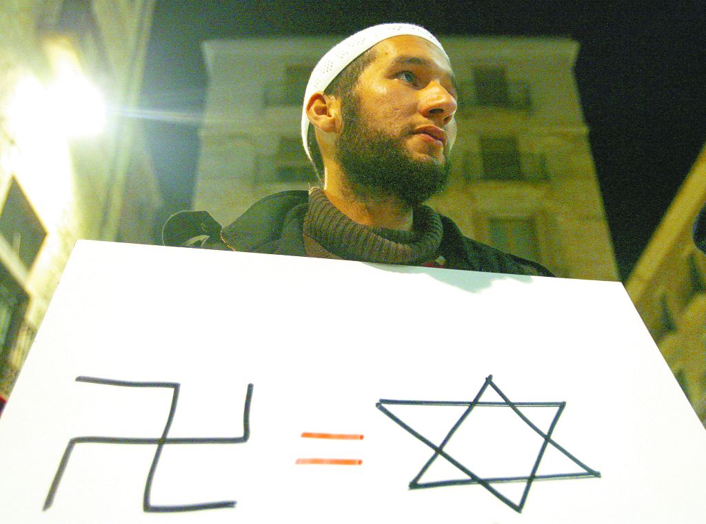 Palestino protesta contra a ação militar na Faixa de Gaza: comparação da suástica nazista à estrela de Davi | AFP/ Josep Lago