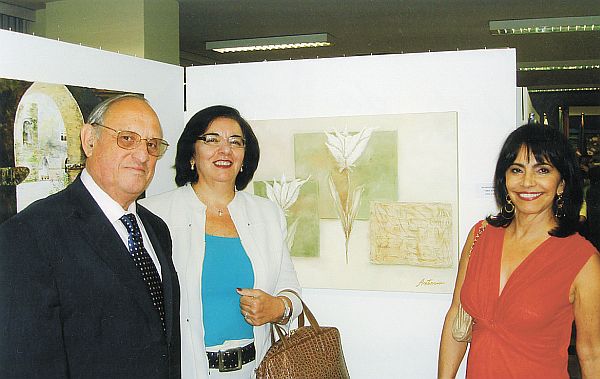 Na abertura da XI Mostra de Arte Câmara Municipal de Curitiba, segunda-feira, o empresário Didio Rocha Loures com a vereadora Julieta Reis e Antônia Rocha Loures, ao lado de sua tela. Título: Amor ao Cubo. | Foto Divulgação