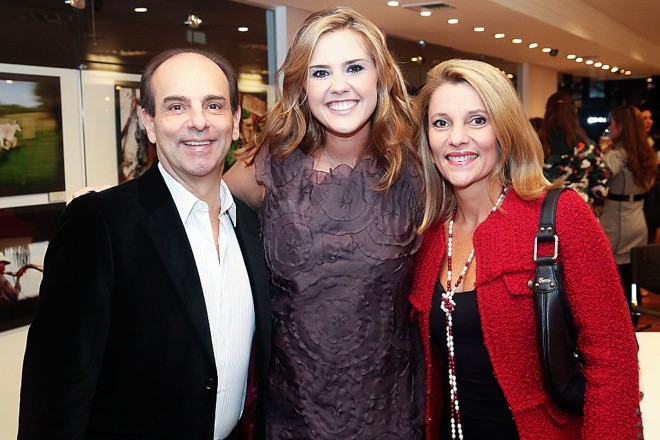 Andrea Ribas (ao centro) com o casal de amigos Flávia e Waldir Simões de Assis na abertura de sua exposição fotográfica