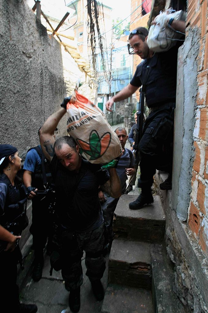 Policiais carregam maconha apreendida durante operação no morro da Mangueira | Severino Silva/Agência O Dia