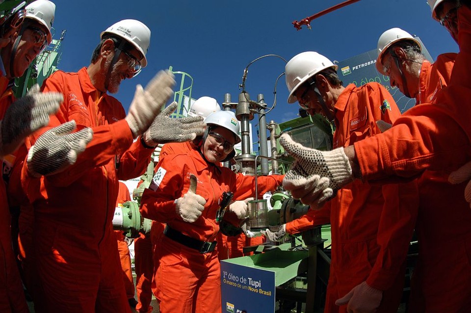 Primeiro óleo extraído da camada pré-sal é celebrado pelo governo O presidente da Petrobras (à esq.) e técnicos da estatal retirando a primeira porção de petróleo de águas ultraprofundas: Lula não foi à plataforma por questões de segurança | Divulgação/Agência Petrobras