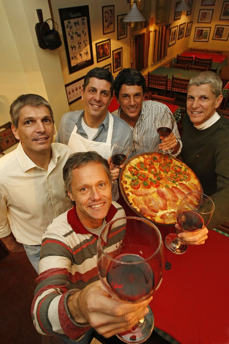 Os irmãos José Antônio, Veriano, Paulo e Luis Afonso Baggio Pereira (todos ao fundo), com o cunhado Julio Alvarez, da Baggio Pizzaria: educação semelhante ajuda nos negócios em família | Marcelo Elias/Gazeta do Povo