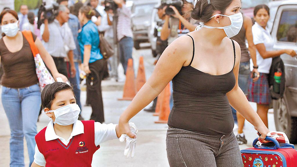 Mãe e filho se protegem com máscaras em rua de Guayaquil, no Equador: primeiro caso de gripe suína foi confirmado no país nesta semana | AFP