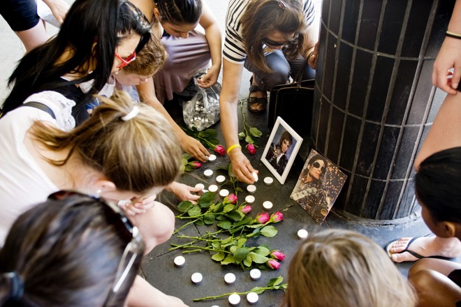 Meninas suecas colocam flores e velas em memória do falecido ícone pop dos EUA Michael Jackson na praça de Sergel no centro de Estocolmo |