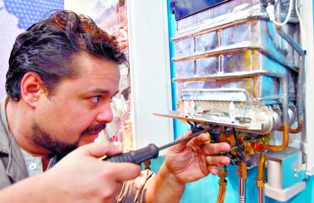 Técnico conserta aquecedor a gás, em Curitiba: manutenção evita vazamento | Valterci Santos/Gazeta do Povo