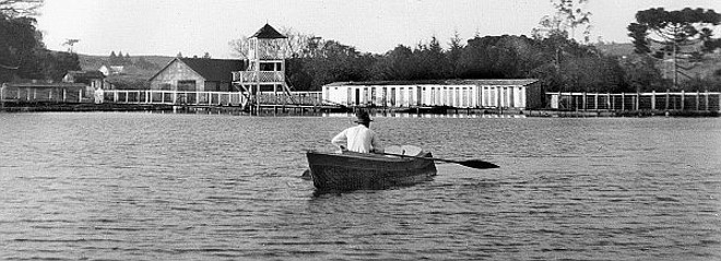 Damos um pulo até o arrabalde do Bacacheri, no ano de 1937, onde podemos apreciar o antigo tanque ali existente no qual a população de Curitiba podia gozar seus momentos de lazer, tanto navegando como usando suas águas para praticar natação. Ao fundo, podemos notar o trampolim e a série de vestiários que ali existiram | 