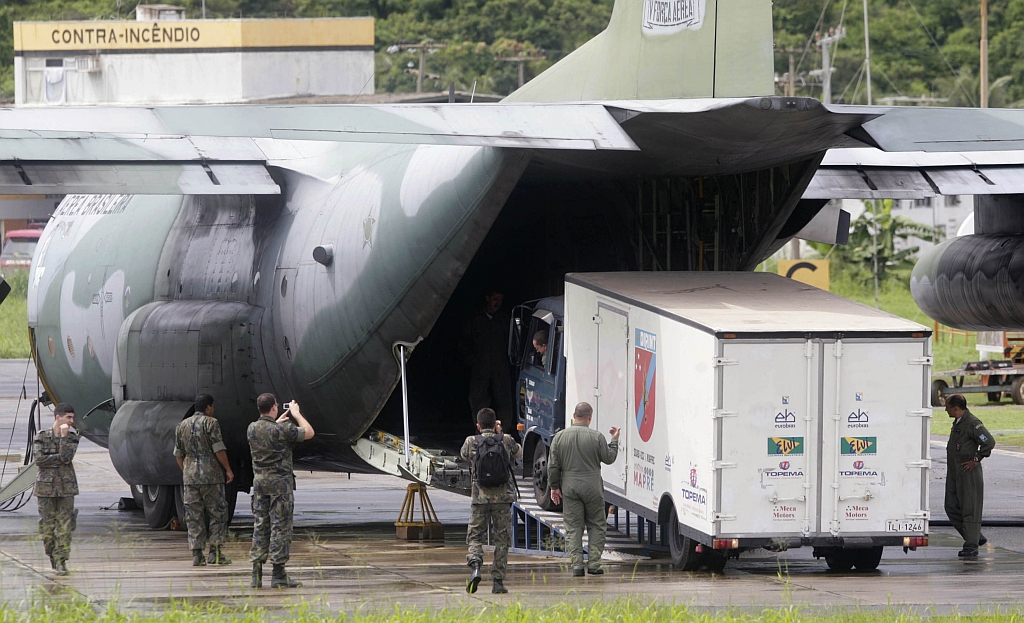 Caminhão refrigerado é descarregado de um Hércules C-130 em Fernando de Noronha: veículo será usado para acondicionar corpos de vítimas do desastre aéreo caso as operações de busca tenham sucesso | Bruno Domingo/Reuters