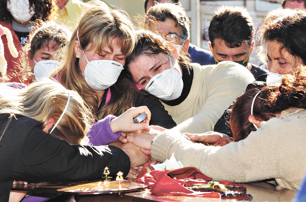 Enterro do corpo da primeira vítima da gripe A no Brasil: parentes e amigos de caminhoneiro morto no Rio Grande do Sul usaram máscaras durante a cerimônia | Genaro Joner/RBS/AFP