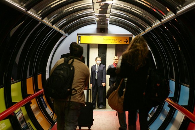 Funcionário da Infraero usa máscara no Aeroporto Afonso Pena, em São José dos Pinhais: passageiros que chegam de viagens a países do Mercosul terão de preencher documento sobre estado de saúde |