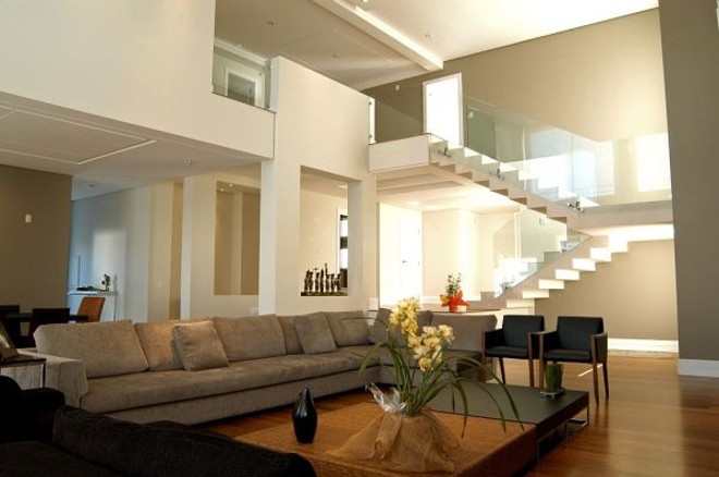 Vidros maiores nas paredes e no guarda-corpo do mezanino privilegiam a entrada de luz natural no projeto de Elke Fadel | 