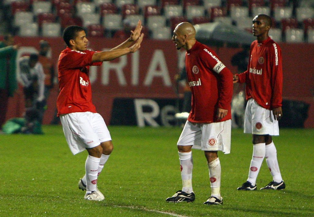 Autor de um dos gols da vitória colorada, Taison (esq.) recebe cumprimento de Guiñazu | Lucas Uebel/Vipcomm